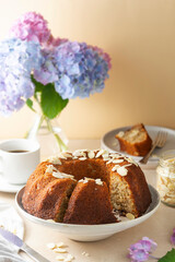 Traditional bundt cake, homemade pastry baked round cake with coffee cup and flowers on background