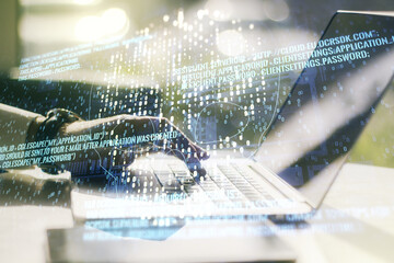 Creative code skull hologram and hands typing on computer keyboard on background, cybercrime and hacking concept. Multiexposure