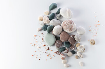 body and soul care banner, colored round stones, sea salt on white background, top view, empty space for text