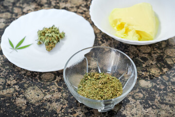 Ingredients to prepare cannabis butter or cannabutter. Kitchen table with marijuana and butter for...