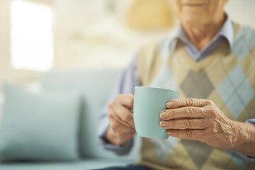 Pensioner resting at home with a cup of hot tea