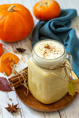 Autumn drink. Pumpkin spiced latte or coffee in glass on a rustic wooden table.