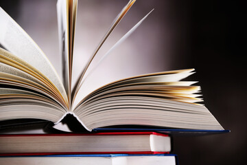 Hardcover book lying on a stack of other books