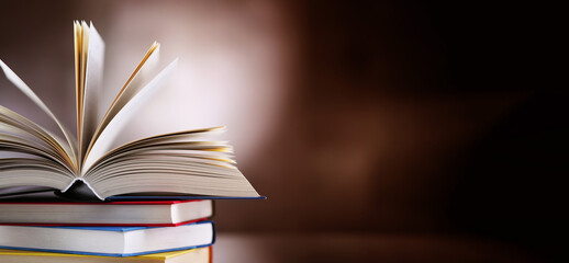 Hardcover book lying on a stack of other books