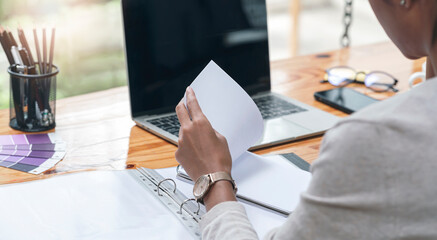 Cropped shot of woman hand working with document while sitting at office.