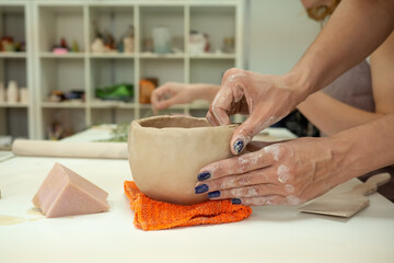 Woman hand potter making clay cup in pottery workshop studio. Process of creating ceramic mug. Handmade, hobby art and handicraft concept