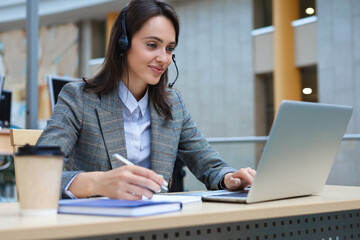 Fototapeta premium Woman customer support operator with headset and smiling.