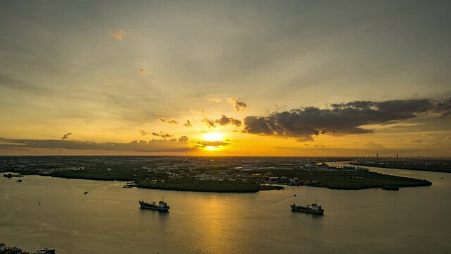 Bird's eye view of Samut Prakan, Thailand. Sunset over the Chao Phraya River, orange sky.