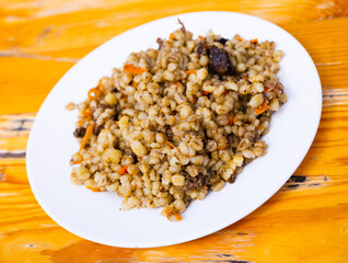 pearl barley porridge with mushrooms on a white plate