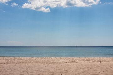 Tropical beach view. Calm and relaxing empty beach scene, blue sky and white sand.