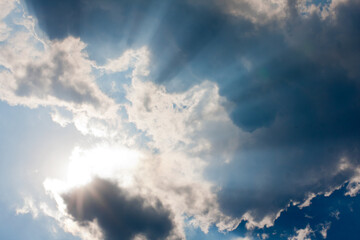 Beautiful blue sky with sunbeams and clouds. Sun rays.