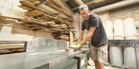 Carpenter processes wood in a furniture workshop. Woodworking and crafts tools