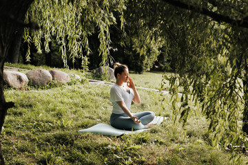 Young athletic woman during yoga class performing Pranayama breathing practice, exercise with...