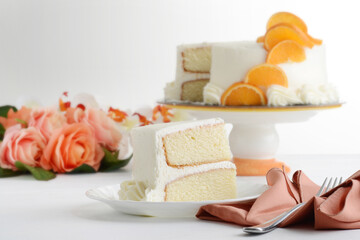 slice of vanilla cake on plate with napkin and fork