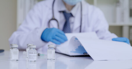 Doctor reading files of register patient data of Covid-19 vaccine