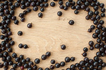 Fresh organic berries, black currant on wooden table. Frame, copy space for inscription