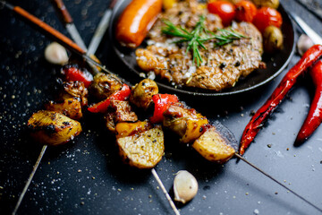 Steak on the plate and black background sprinkled with salt and pepper.
