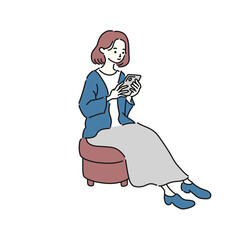 椅子に座ってスマートフォンを見る女性