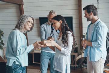 Naklejka premium Happy senior parents meeting young couple inside the house