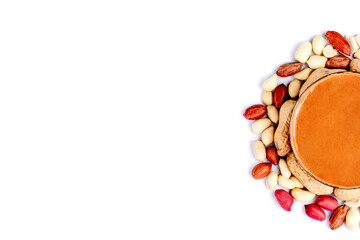 Peanut butter isolated and peanuts in the peel scattered on the white background. Copy space.