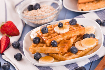 Waffles with blueberries, bananas and honey.