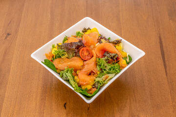 Scandinavian salad with smoked salmon, pieces of orange and lots of lettuce, escarole and olive oil