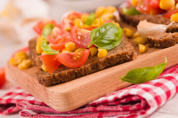 Rye bread withsweet corn, basil and tomato.