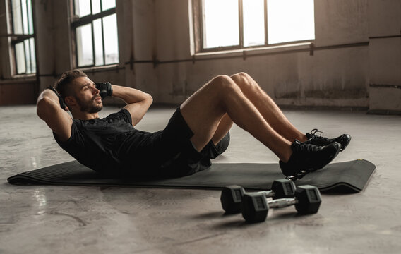 Sportsman doing abdominal crunches in gym