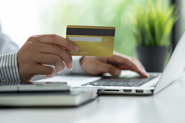 Close up woman hand using credit card and computer laptop for buying online shopping