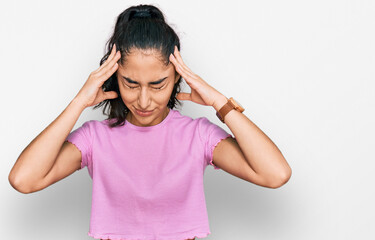 Hispanic teenager girl with dental braces wearing casual clothes suffering from headache desperate and stressed because pain and migraine. hands on head.