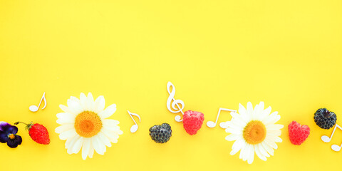 banner treble clef and music notes with flowers and berries on a yellow background. summer music concept..