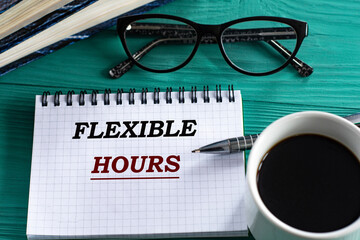 FLEXIBLE HOURS - words in a notepad on a wooden green background with a calculator, pen and glasses