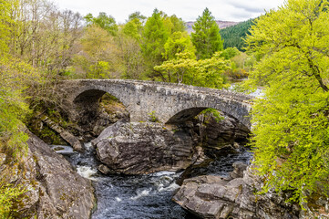 Fototapeta na wymiar A view of the old stone bridge at Invermoriston, Scotland on a summers day