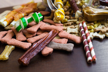 Dog tasty colored biscuits on wooden background, snacks for dogs. Healthy dry pet food concept