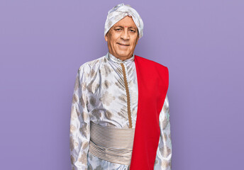 Senior hispanic man wearing tradition sherwani saree clothes relaxed with serious expression on face. simple and natural looking at the camera.