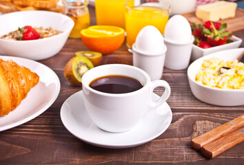 Cup of coffee, juice, eggs, fruits, toasts. Breakfast concept.