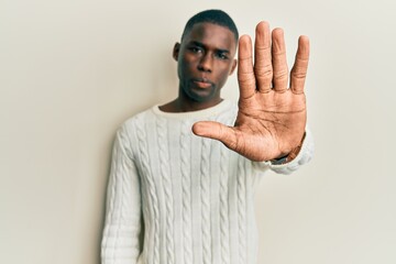 Young african american man wearing casual clothes doing stop sing with palm of the hand. warning...