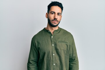 Young hispanic man wearing casual clothes puffing cheeks with funny face. mouth inflated with air, crazy expression.