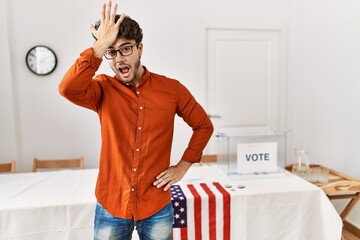 Hispanic man standing by election room surprised with hand on head for mistake, remember error....