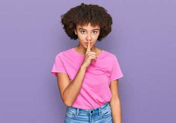 Fototapeta na wymiar Young hispanic girl wearing casual clothes asking to be quiet with finger on lips. silence and secret concept.
