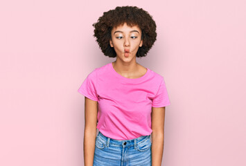 Young hispanic girl wearing casual clothes making fish face with lips, crazy and comical gesture. funny expression.