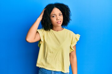 Young african american girl wearing casual clothes confuse and wonder about question. uncertain with doubt, thinking with hand on head. pensive concept.