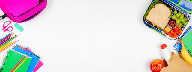 Healthy school lunch with school supplies. Overhead view double border on a white banner background. Back to School concept.