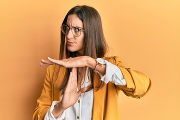 Young beautiful woman wearing business style and glasses doing time out gesture with hands,...