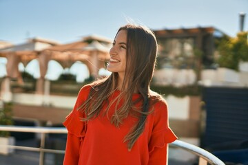 Obraz premium Young hispanic woman smiling happy standing at the city.