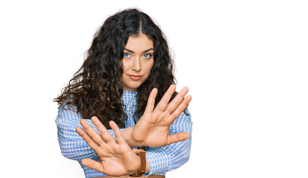 Young hispanic girl wearing casual clothes rejection expression crossing arms doing negative sign, angry face