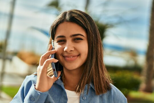 Young latin girl smiling happy talking on the smartphone at the city.