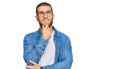 Fototapeta premium Young caucasian man wearing casual clothes with hand on chin thinking about question, pensive expression. smiling and thoughtful face. doubt concept.