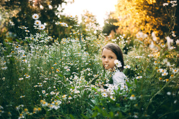 Girl in the field with daisies, childhood and summer vacation concept