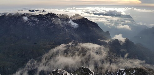 Rwenzori Mountains National Park, Uganda - February 26, 2020: Few quarters after sunrise, clouds and mountains seen from Margherita Peak